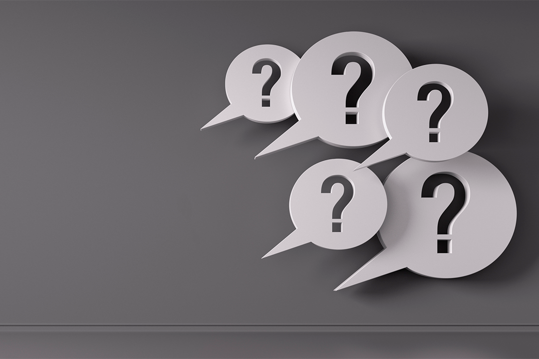 five white speech bubbles with question marks of varying size on a gray background